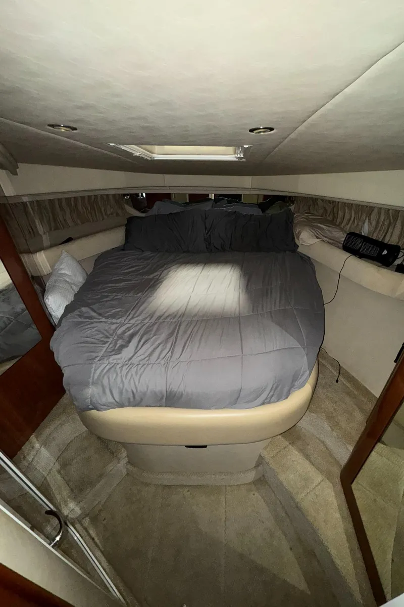 Slide: The Image of 2002 Sea Ray 410 Sundancer cabin with a cozy bed and modern interior design. - 9