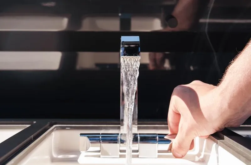 Slide: The Image of Hand adjusting modern Navan S30 faucet, 2025 model, with water flowing in a sink. - 17