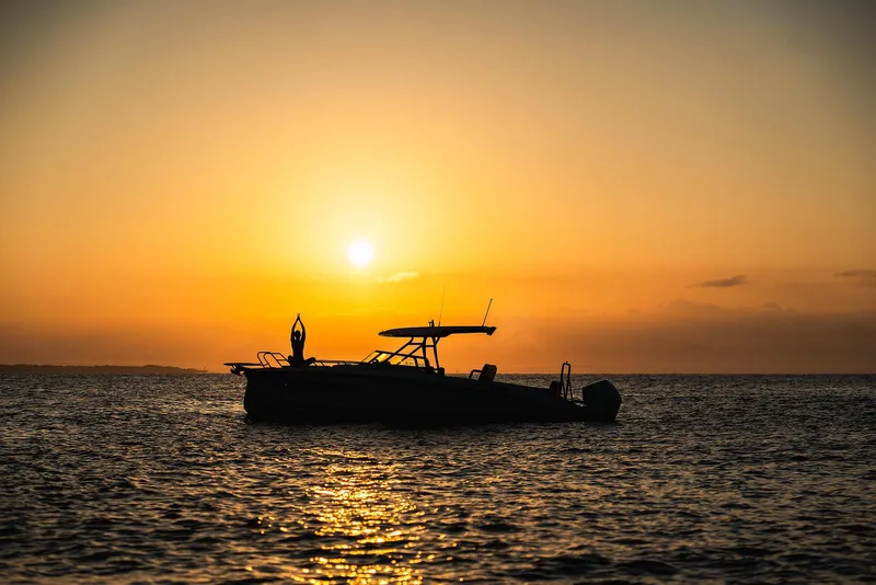 Slide: The Image of Navan S30 boat silhouetted against a stunning sunset over the ocean, 2025 model. - 18