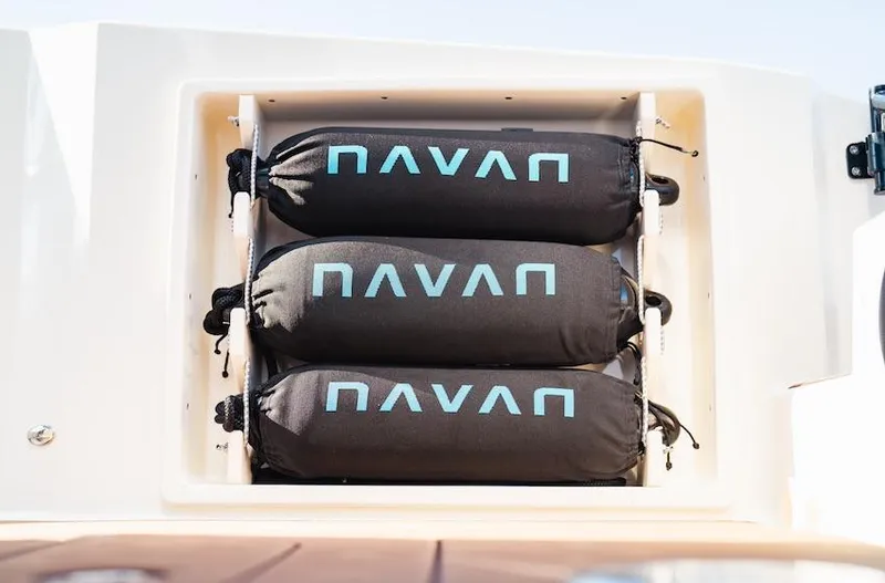 Slide: The Image of Navan S30 2025 storage compartment with three black cylindrical bags. - 26