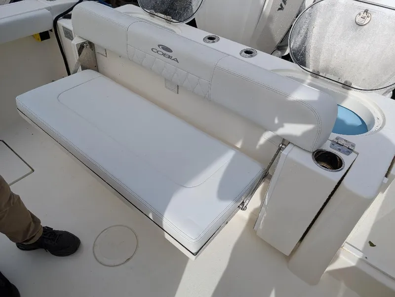 Slide: The Image of 2023 Cobia 301 Center Console boat with white cushioned seating and cup holders. - 20