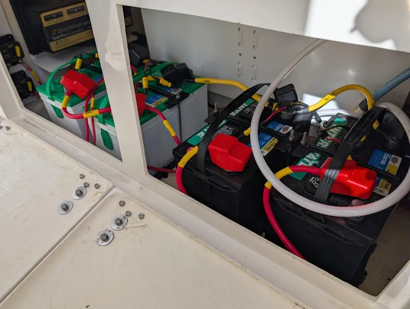 Slide: The Image of 2023 Cobia 301 Center Console boat battery compartment with multiple connected batteries. - 23