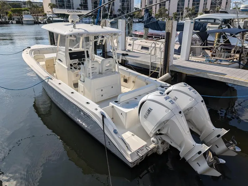 Slide: The Image of 2023 Cobia 301 Center Console boat docked with twin Yamaha engines. - 3