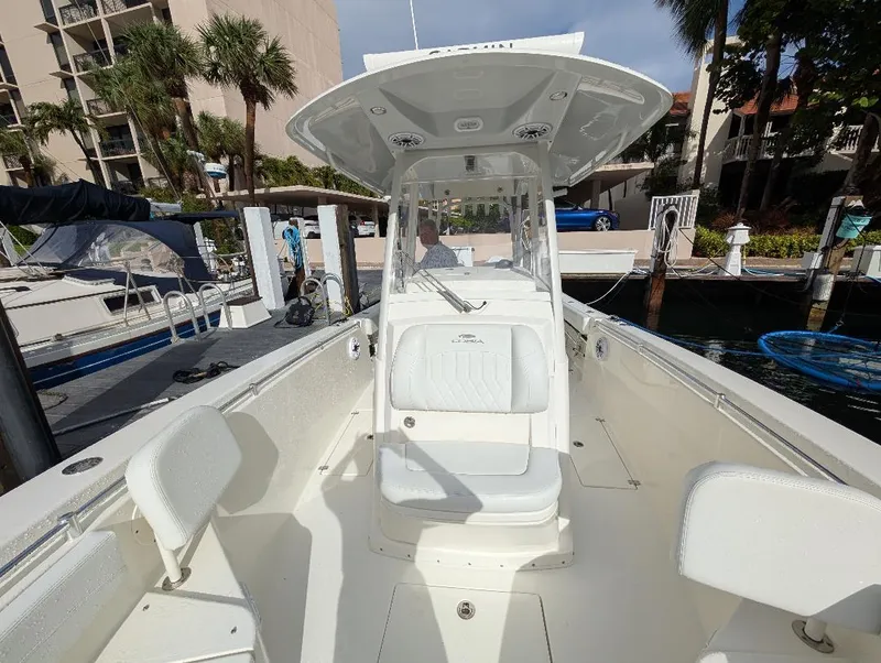 Slide: The Image of 2023 Cobia 301 Center Console boat docked, featuring spacious seating and modern design. - 31