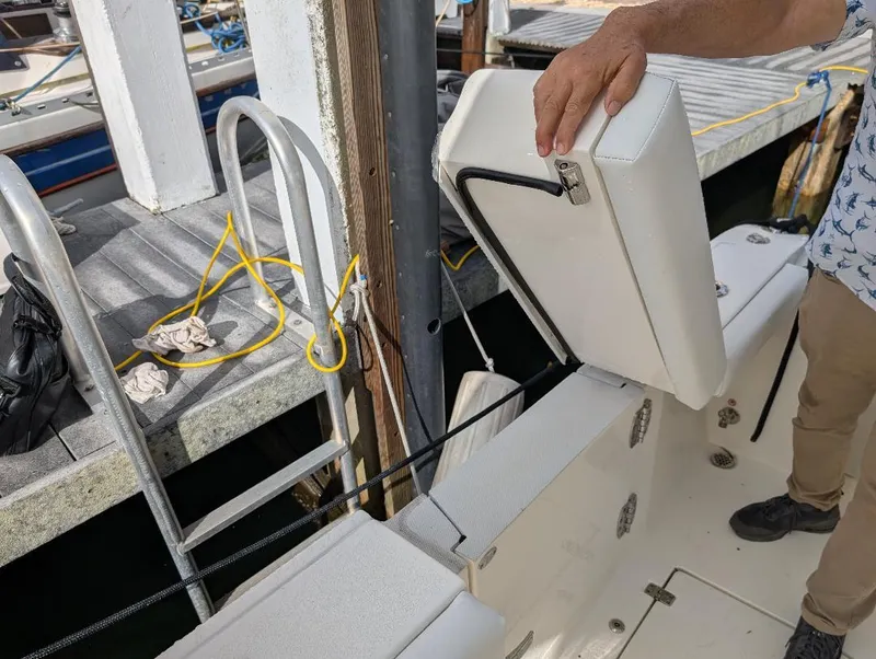 Slide: The Image of 2023 Cobia 301 Center Console boat docked, featuring a Garmin radar system, surrounded by lush greenery. - 35