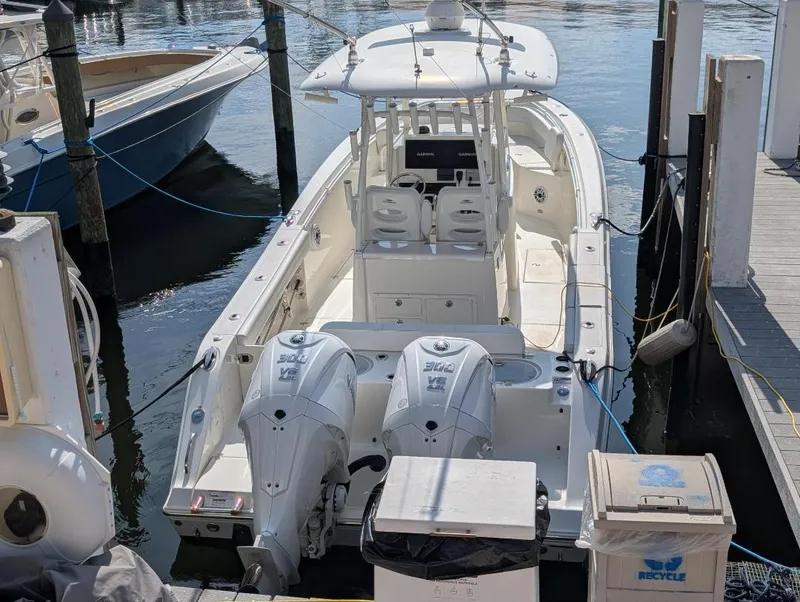 Slide: The Image of 2023 Cobia 301 Center Console boat docked with twin engines. - 8