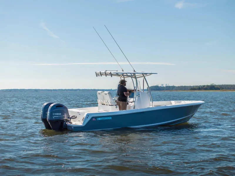 Slide: The Image of 2022 Contender 25 boat on water with dual Yamaha engines, clear sky background. - 15