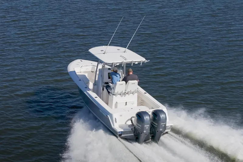 Slide: The Image of 2022 Contender 25 boat cruising on open water with dual engines. - 18