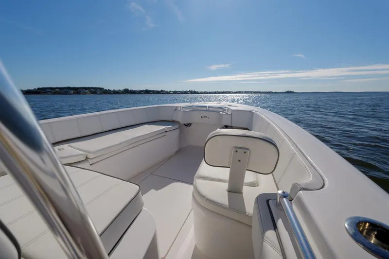 Slide: The Image of Contender 25 boat interior, 2022 model, on calm water under clear blue sky. - 7