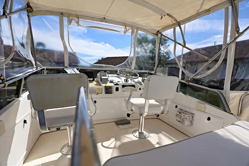 Slide: The Image of 2000 Legacy Flybridge Downeast boat interior with helm and seating under canopy. - 17