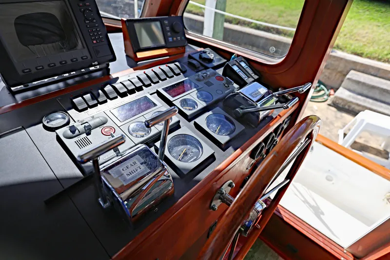 Slide: The Image of Control panel of a 2000 Legacy Flybridge Downeast boat with gauges and navigation equipment. - 29