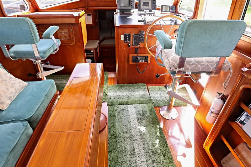 Slide: The Image of Interior of 2000 Legacy Flybridge Downeast boat with wooden finish and green seating. - 32