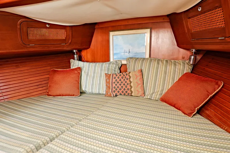 Slide: The Image of Cozy cabin interior of 2000 Legacy Flybridge Downeast with striped bedding and decorative pillows. - 36