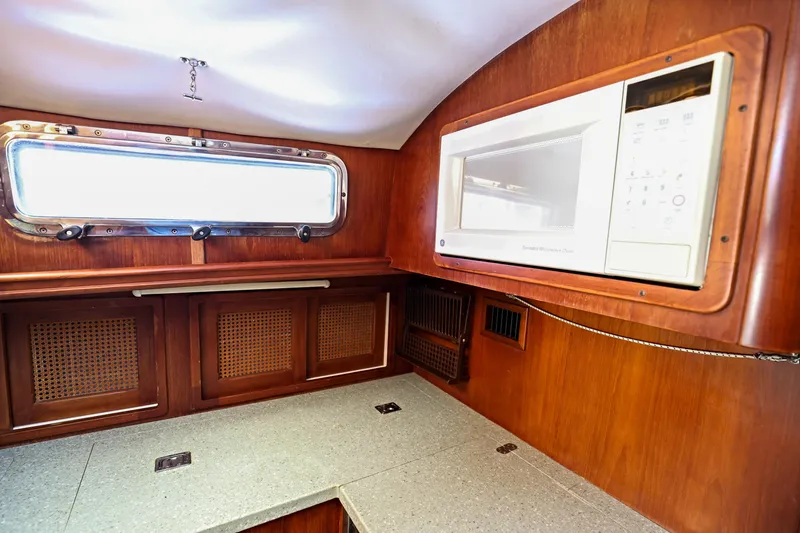 Slide: The Image of Interior of 2000 Legacy Flybridge Downeast boat with wood cabinetry and built-in microwave. - 45