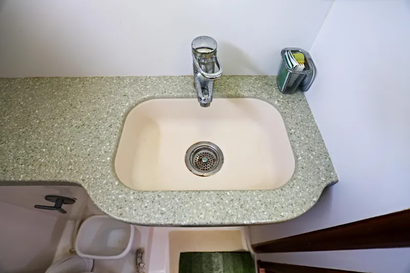 Slide: The Image of Legacy Flybridge Downeast 2000 boat sink with granite countertop and modern faucet. - 49