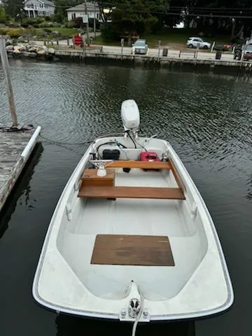 Slide: The Image of 1981 Boston Whaler 13 boat docked on calm water, featuring wooden seating and outboard motor. - 4