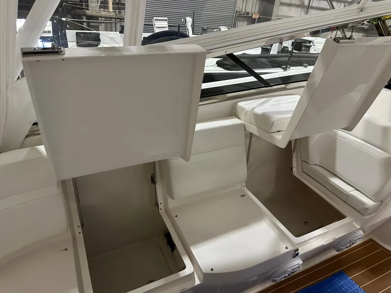 Slide: The Image of 2017 Intrepid 430 Sport Yacht interior storage compartments open, showcasing spacious design. - 14
