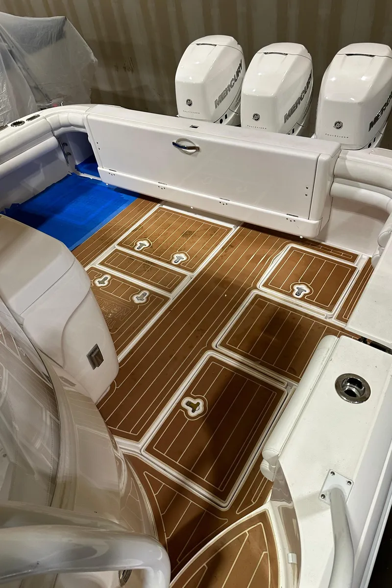 Slide: The Image of 2017 Intrepid 430 Sport Yacht deck with teak flooring and multiple outboard engines. - 20