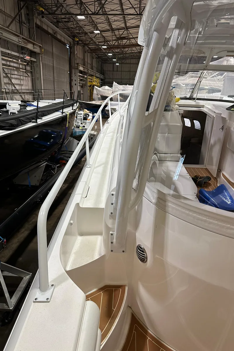Slide: The Image of 2017 Intrepid 430 Sport Yacht in a warehouse, showcasing sleek design and spacious deck. - 32
