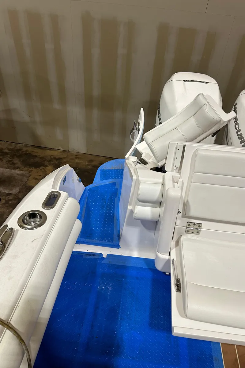 Slide: The Image of 2017 Intrepid 430 Sport Yacht with white seating and blue deck, featuring powerful outboard engines. - 33