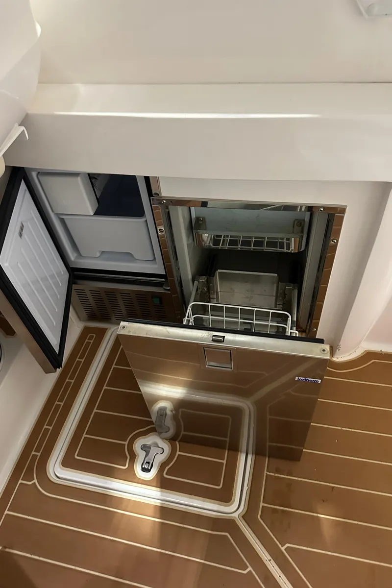 Slide: The Image of 2017 Intrepid 430 Sport Yacht interior with open refrigerator and wooden flooring. - 35