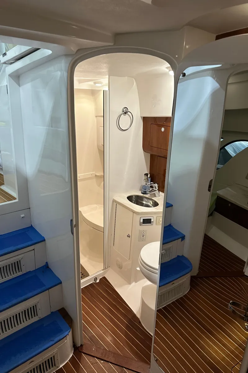 Slide: The Image of 2017 Intrepid 430 Sport Yacht interior with bathroom, wooden flooring, and blue-accented stairs. - 44