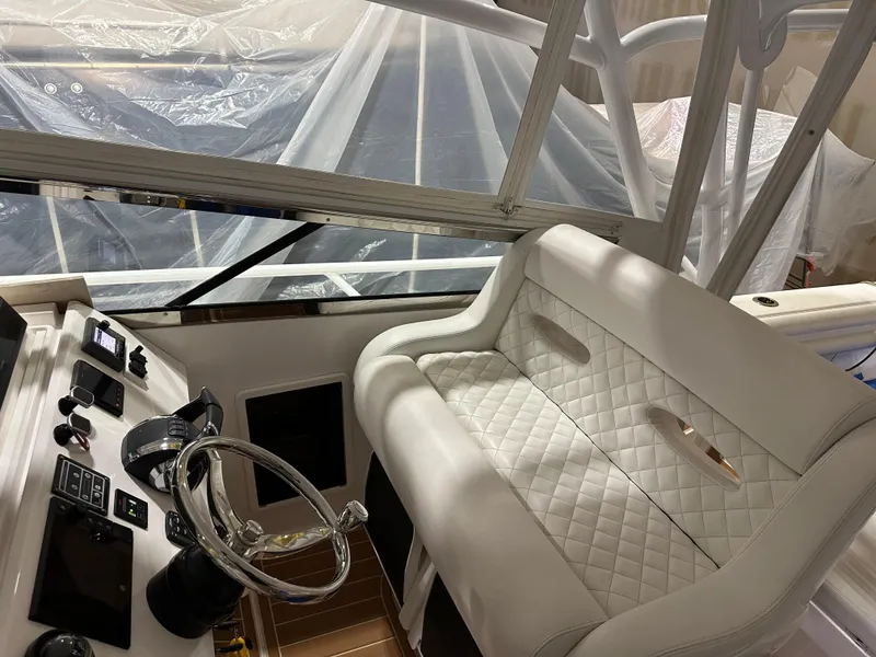 Slide: The Image of 2017 Intrepid 430 Sport Yacht helm with luxurious white seating and modern controls. - 6