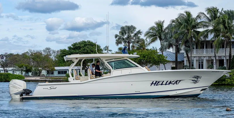 The Image of 2019 Scout 420 LXF boat named "Hellkat" cruising on a scenic waterway. - 0