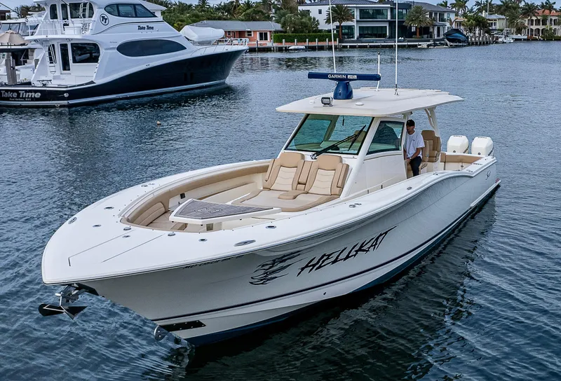 Slide: The Image of 2019 Scout 420 LXF boat named "Hellkat" cruising on a calm waterway. - 17