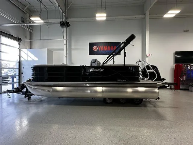 Slide: The Image of 2025 Bentley Pontoons 200 Navigator in showroom, sleek black design, Yamaha sign in background. - 3