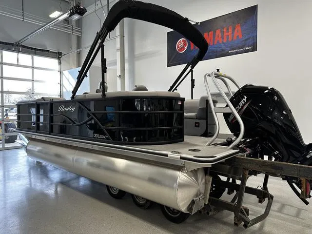 Slide: The Image of 2025 Bentley Pontoons 200 Navigator in showroom, featuring sleek design and Mercury outboard motor. - 4