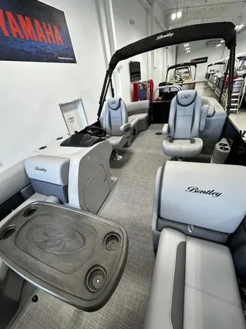 Slide: The Image of 2025 Bentley Pontoons 200 Navigator interior with seating and table, showcased in a showroom. - 9