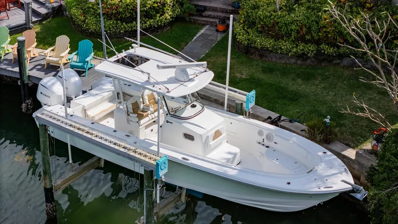 Slide: The Image of 2019 Edgewater 320CC boat docked by lush greenery. - 11