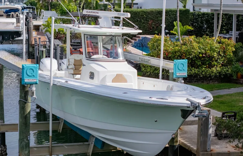 Slide: The Image of 2019 Edgewater 320CC boat docked at marina, surrounded by lush greenery. - 15
