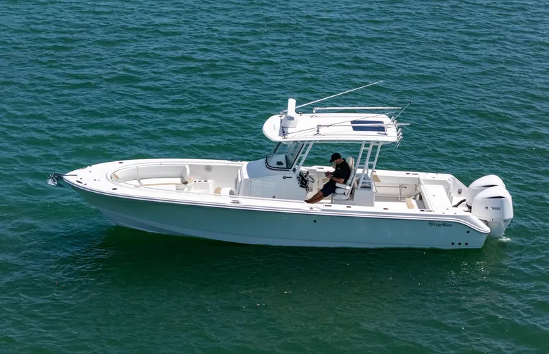 Slide: The Image of 2019 Edgewater 320CC boat on open water, featuring sleek design and spacious deck. - 2