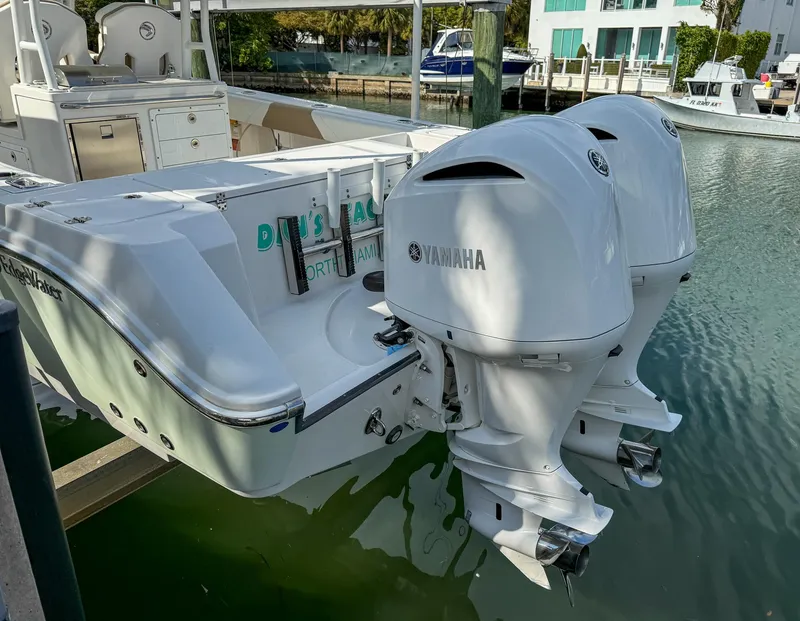 Slide: The Image of 2019 Edgewater 320CC boat with twin Yamaha outboard engines docked in marina. - 20