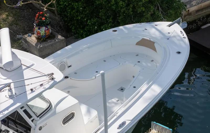 Slide: The Image of 2019 Edgewater 320CC boat docked, featuring spacious white deck and sleek design. - 22