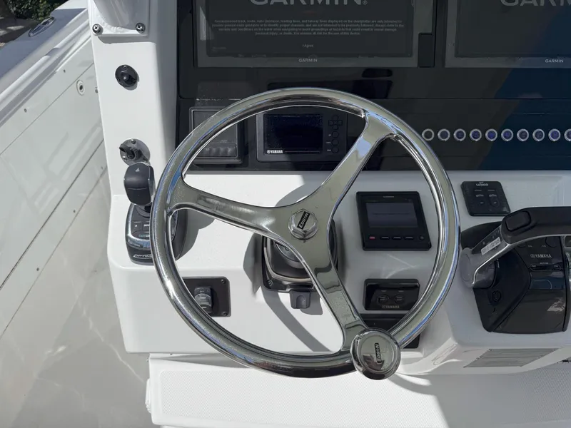 Slide: The Image of Steering wheel and controls of 2019 Edgewater 320CC boat cockpit. - 24
