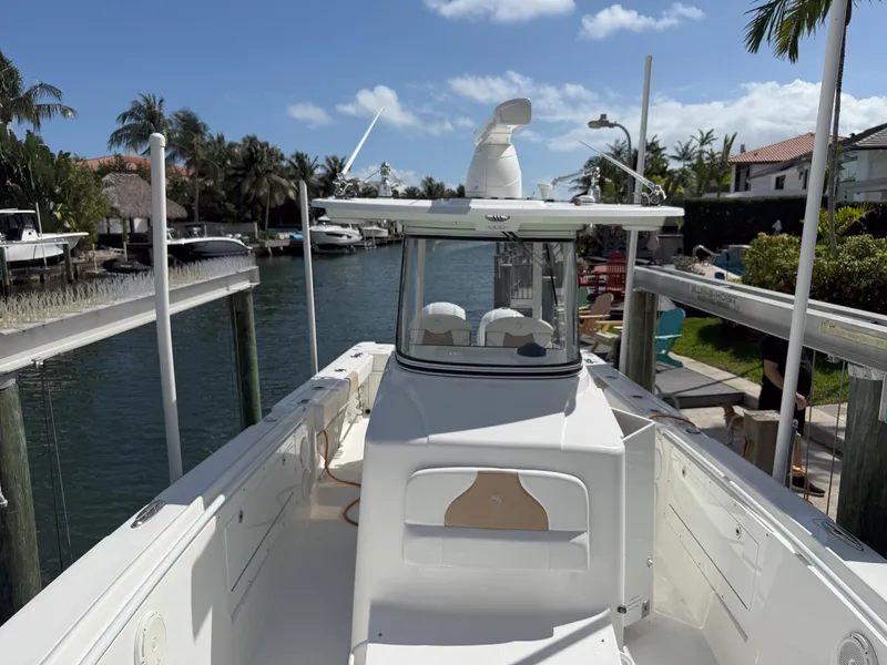 Slide: The Image of 2019 Edgewater 320CC boat docked in a scenic canal with palm trees. - 26