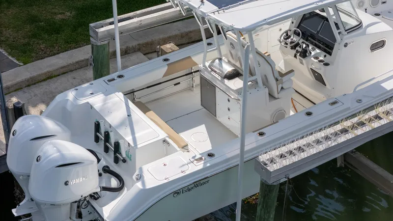 Slide: The Image of 2019 Edgewater 320CC boat docked, featuring dual Yamaha engines and spacious cockpit. - 30