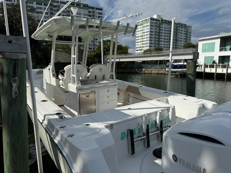 Slide: The Image of 2019 Edgewater 320CC boat docked near waterfront buildings. - 32