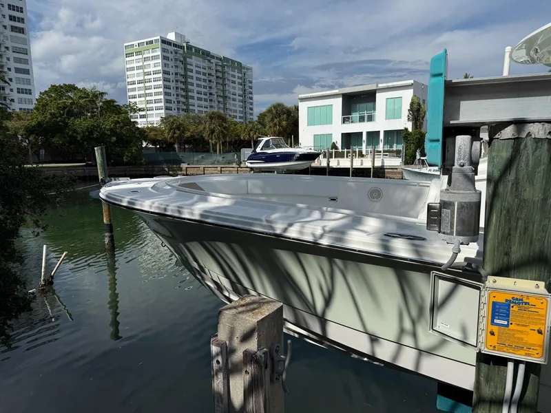 Slide: The Image of Edgewater 320CC 2019 boat docked near modern waterfront buildings. - 33