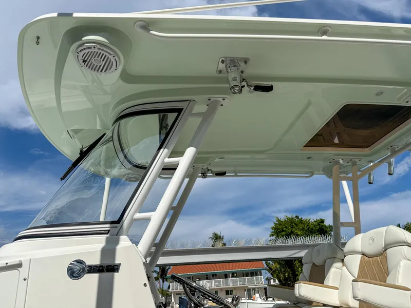 Slide: The Image of 2019 Edgewater 320CC boat with sleek design and comfortable seating under a clear blue sky. - 35