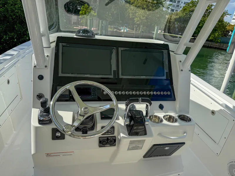 Slide: The Image of Edgewater 320CC 2019 boat dashboard with dual screens and steering wheel. - 41