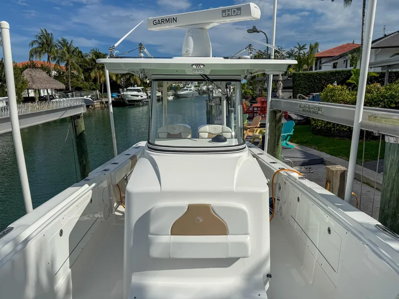 Slide: The Image of 2019 Edgewater 320CC boat docked in a scenic canal with palm trees. - 46