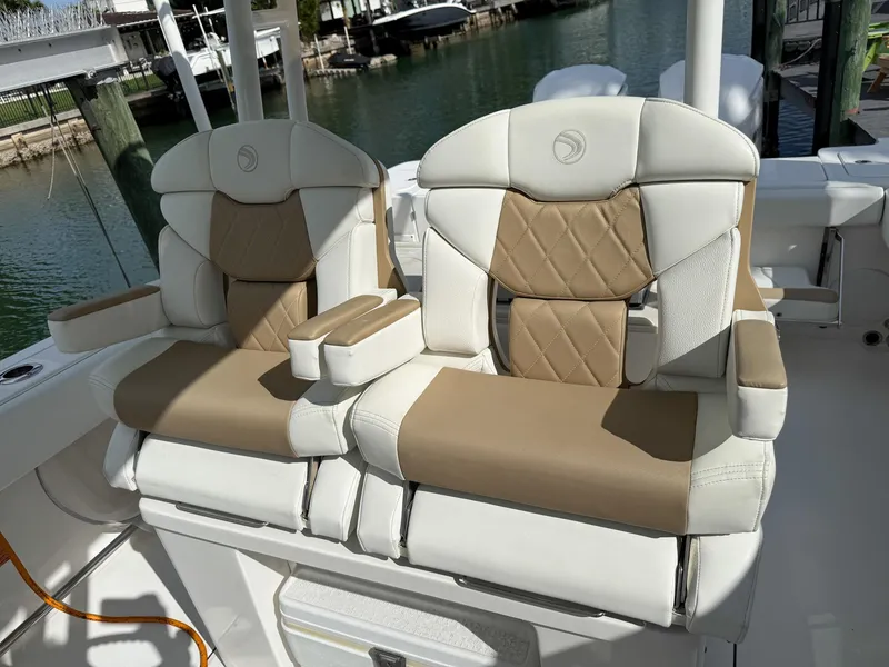 Slide: The Image of Luxurious seating on 2019 Edgewater 320CC boat, featuring tan and white upholstery. - 47