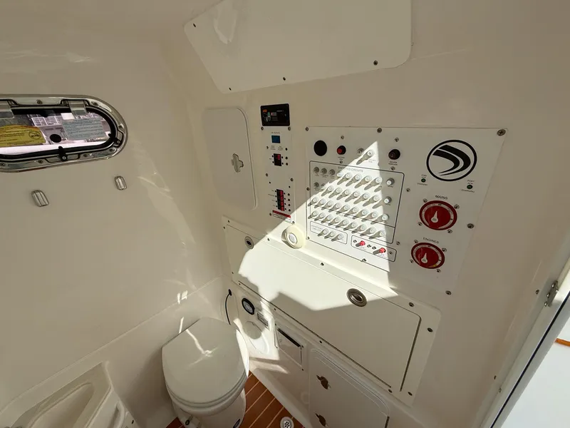 Slide: The Image of 2019 Edgewater 320CC boat interior with control panel and toilet. - 49
