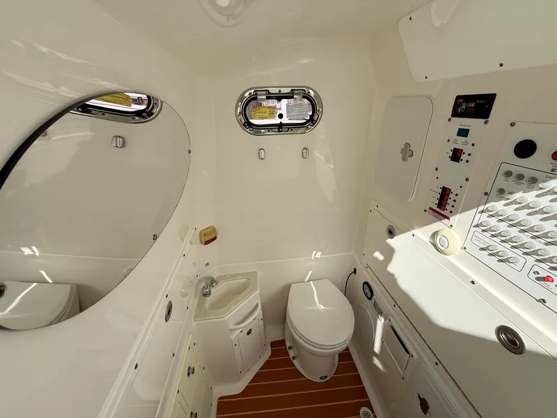 Slide: The Image of Interior of 2019 Edgewater 320CC boat bathroom with toilet, sink, and control panel. - 50
