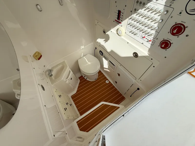 Slide: The Image of 2019 Edgewater 320CC boat interior with toilet and control panel. - 51