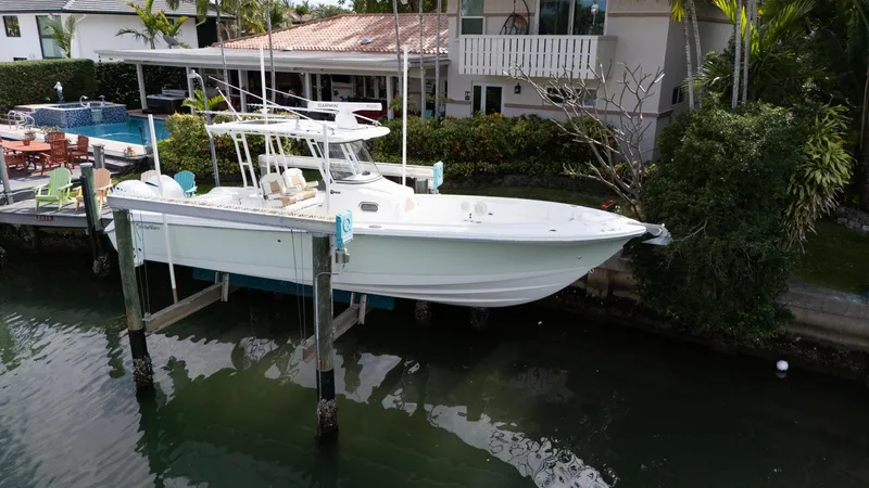 Slide: The Image of 2019 Edgewater 320CC boat docked near waterfront home. - 6